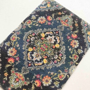 May include: A blue rug with a floral pattern in shades of yellow, red, and white. The rug has a central medallion with a geometric design.