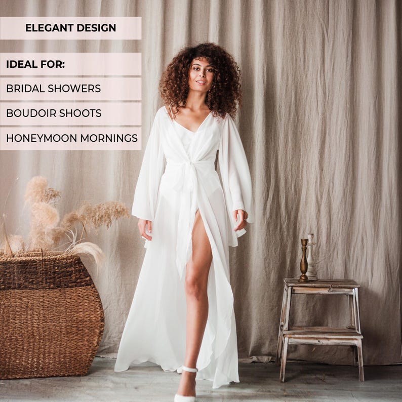May include: A white, flowing robe with long sleeves and a tie waist. The robe is open in the front, revealing a glimpse of the legs. The text "ELEGANT DESIGN" is at the top of the image.
