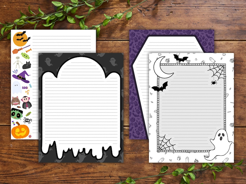 Może przedstawiać: Kolekcja artykuł&oacute;w papierniczych o tematyce Halloween. Zawiera liniowany papier listowy z dekoracyjnymi obramowaniami z nietoperzami, duchami, dyniami i innymi upiornymi elementami. Artykuły papiernicze są umieszczone na drewnianym tle z zielonymi liśćmi.