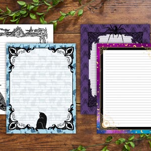 Op de afbeelding: Een verzameling gelinieerde briefpapierbladen met decoratieve randen. Ontwerpen omvatten een raaf, een zwarte kat, spinnenwebben en hemelse patronen. Het kleurenpalet bevat zwarte, witte, blauwe, paarse en gouden accenten, perfect voor gothic of Halloween-thema's.