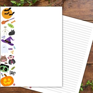 Może przedstawiać: Biały papier listowy o tematyce Halloween z dekoracyjną obw&oacute;dką z kresk&oacute;wkowymi nietoperzami, dynią, kapeluszem czarownicy, duchem i innymi upiornymi elementami. Papier w linie jest idealny do notatek lub list&oacute;w.
