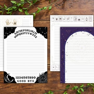 Puede incluir: Una colección de papelería con líneas con temas celestiales y ocultos. Los diseños incluyen una tabla Ouija, constelaciones y símbolos de manos. La papelería presenta el alfabeto, números y las palabras "Good Bye". El papel es blanco con detalles en negro y dorado.