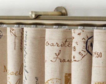 May include: A beige curtain with a printed pattern of handwritten text and stamps. The curtain is hung on a metal rod with a decorative finial.