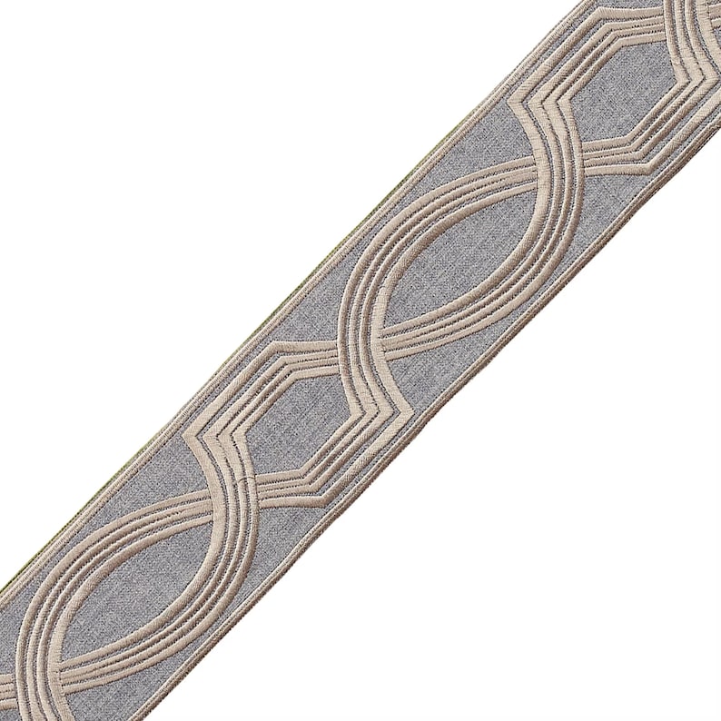 May include: A gray and beige trim with a geometric pattern. The trim features a repeating design of interlocking circles and hexagons.