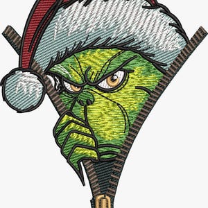 May include: Embroidered design of a green character with an angry expression, wearing a Santa hat. The character's face is framed by a zipper, with the zipper pull at the bottom. The design features shades of green, red, white, and brown.