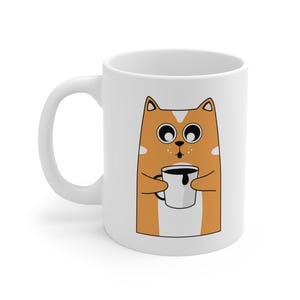 Könnte beinhalten: Weiße Keramik-Kaffeetasse mit einer Cartoon-Katze mit orangefarbenem Fell, die eine weiße Tasse mit schwarzer Flüssigkeit hält. Die Katze hat große Augen und einen weißen Fleck auf dem Kopf. Die Tasse hat einen gebogenen Griff.