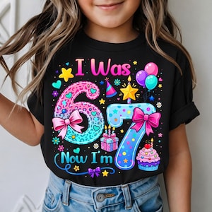以下が含まれることがあります： 「I Was 6, Now I'm 7」とカラフルな文字と数字で書かれた黒いTシャツ。デザインには、カップケーキ、風船、ギフトボックスが含まれており、誕生日のパーティーに最適です。