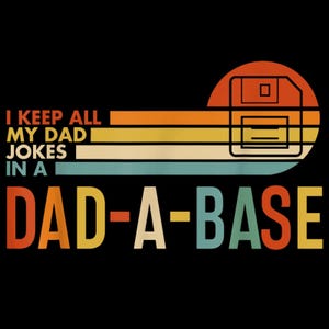 May include: Black t-shirt design with the text "I KEEP ALL MY DAD JOKES IN A DAD-A-BASE". The design features a retro color scheme with orange, yellow, and teal stripes, and a floppy disk graphic.