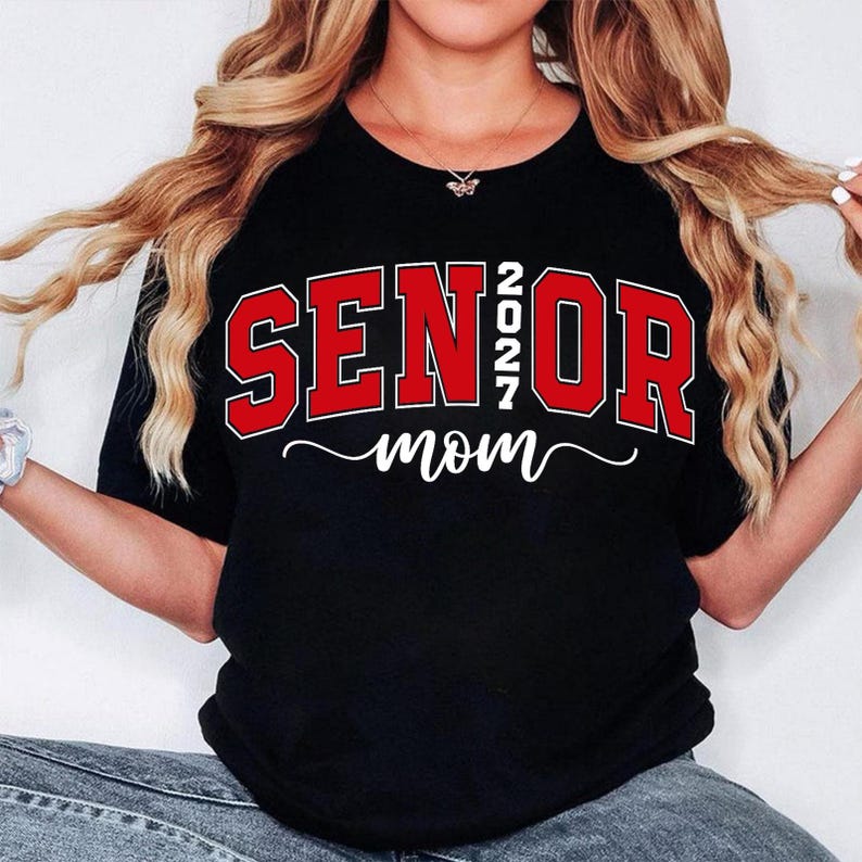 K&ouml;nnte beinhalten: Schwarzes T-Shirt mit dem Aufdruck "SENIOR 2027 mom" in Rot und Wei&szlig;. Das Wort "SENIOR" ist in fetten Blockbuchstaben mit roter Umrandung gehalten. Das Jahr "2027" ist vertikal zwischen "SENIOR" und "OR" gestapelt. Das Wort "mom" ist kursiv geschrieben.