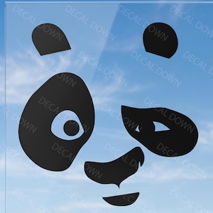 Puede incluir: Un adhesivo de vinilo negro que presenta los rasgos faciales estilizados de un panda, incluyendo dos orejas redondeadas, dos grandes parches oculares con pupilas circulares, una nariz triangular y una pequeña boca curva, con el texto DECAL DOWN repetido.