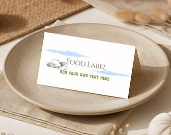 Könnte beinhalten: Eine gefaltete weiße Speisekartenkarte mit einer Cowboyhut-Illustration, blauen Wolkenakzenten und dem Text "FOOD LABEL" und "ADD YOUR OWN TEXT HERE". Die Karte liegt auf einem beigen Teller und einer beigen Serviette.