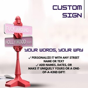 May include: A red custom sign with two pink street signs that read "FUCK AROUND ST" and "HOLLYWOOD BLVD". The sign also includes the text "CUSTOM SIGN" and "YOUR WORDS, YOUR WAY".