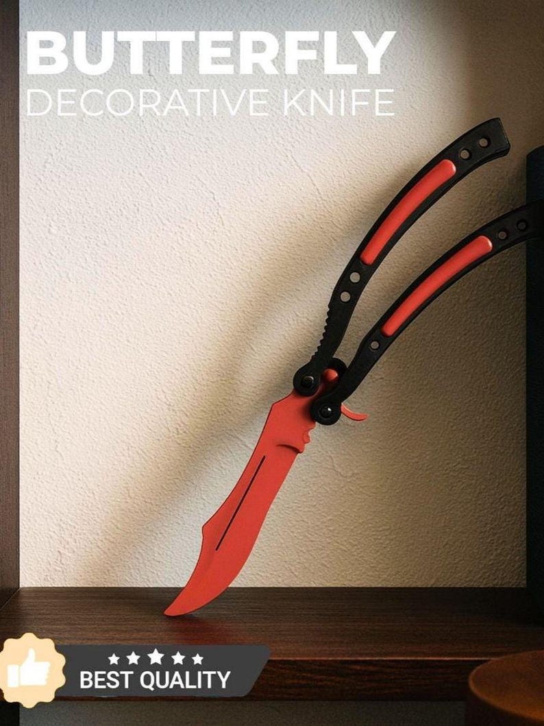May include: A decorative butterfly knife with a red blade and black handle. The text "BUTTERFLY DECORATIVE KNIFE" is displayed at the top of the image. The knife is resting on a wooden surface. The words "BEST QUALITY" are displayed at the bottom.
