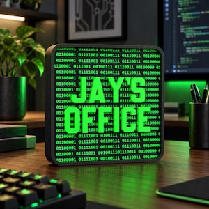 May include: A square black sign featuring a bright green digital background of binary code with the text JAY'S OFFICE displayed in large, raised, three-dimensional green letters centered on the front surface of the display.