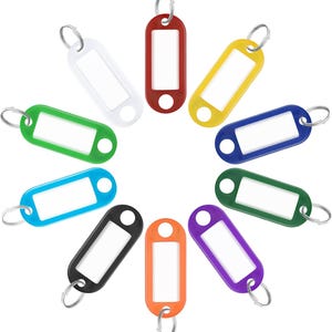 May include: A collection of colorful key tags in a circular arrangement. The tags are in various colors, including white, red, yellow, blue, green, black, orange, and purple. Each tag has a silver key ring and a rectangular label area.