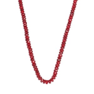 May include: A necklace composed of small, faceted, deep red beads. The beads are strung together to form a continuous strand. The necklace is displayed against a white background, highlighting the color and texture of the beads.