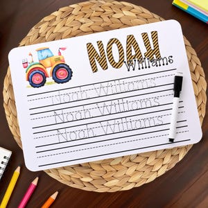 Könnte beinhalten: Weißes Whiteboard mit dem Namen "NOAH Williams" und einer bunten Traktor-Grafik. Das Board hat linierte Bereiche zum Schreiben üben und enthält einen schwarzen Whiteboard-Marker.