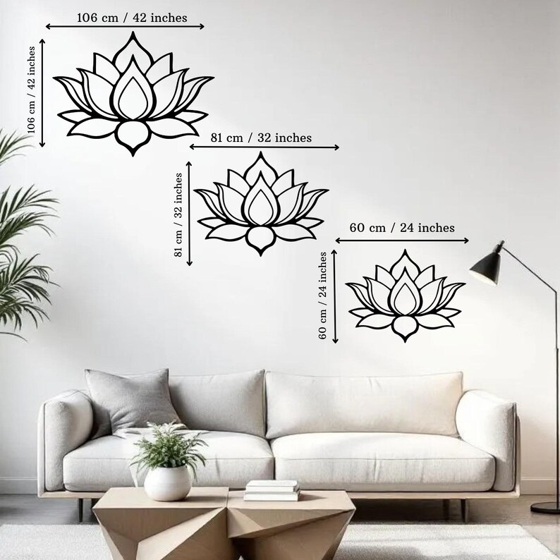 May include: Black lotus flower wall decals in three sizes: 42 inches wide and 42 inches high, 32 inches wide and 32 inches high, and 24 inches wide and 24 inches high. The decals are displayed on a white wall above a sofa.