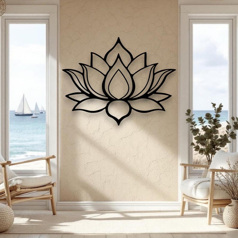 May include: A black metal lotus flower wall art decor. The lotus is a detailed outline of the flower's petals and center. The wall art is mounted on a textured beige wall, with natural light from two windows.