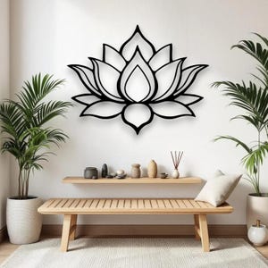 May include: Black metal lotus flower wall art. The floral design is mounted on a white wall above a wooden bench. The room is decorated with potted plants and decorative items, creating a serene atmosphere.