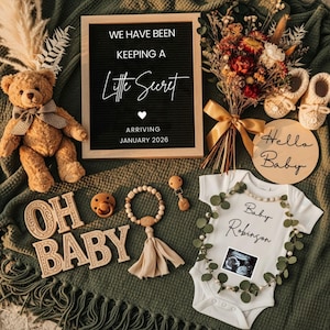 May include: A baby announcement scene with a teddy bear, letter board, and baby clothes. The letter board says "We have been keeping a little secret arriving January 2026." A onesie has the text "Baby Robinson" and a sonogram image.