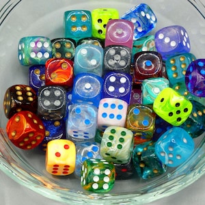 May include: A bowl filled with colorful dice. The dice are made of glass and have different patterns and colors, including blue, green, red, and gold. Some dice have white dots, while others have black dots.