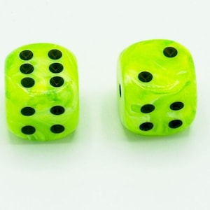 May include: Two green dice with black dots. The dice have a marbled appearance with white swirls.