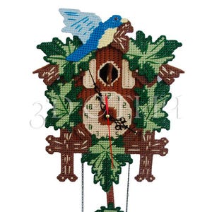 Può includere: Un orologio a cucù decorativo con un uccello in cima. L'orologio presenta una cornice marrone, accenti di foglie verdi e un quadrante color crema. Le lancette dell'orologio sono nere e rosse e il pendolo ha due pesi a forma di piuma color crema.