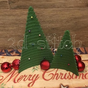 May include: Two green crocheted Christmas trees with colorful bead ornaments and red ornaments. The text "3d-stitch" is overlaid on the trees. The words "Merry Christmas" are visible at the bottom.