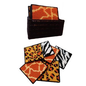 Puede incluir: Un juego de posavasos cuadrados con diseños de animales, incluyendo patrones de jirafa, leopardo y cebra. Los posavasos son de color naranja, negro y blanco. Se guardan en un soporte marrón oscuro.