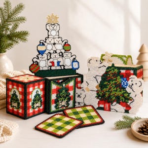May include: A selection of handmade Christmas decorations. Features a polar bear Christmas tree, decorative boxes with festive designs, and green and white plaid coasters. The colour scheme includes red, green, white, and gold.