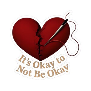 May include: A sticker featuring a red, broken heart being sewn together with a needle and thread. The text "It's Okay to Not Be Okay" is printed in a beige color below the heart. The sticker has a white border.