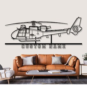 May include: Black metal helicopter wall art with the text "CUSTOM NAME" below. The helicopter is a detailed outline, suitable for home decor. The artwork is displayed above a brown leather sofa.