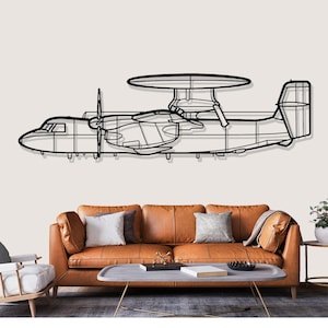 May include: Black metal wall art depicting an airplane with a large, circular radar dome. The aircraft has two propellers and a detailed outline. The artwork is mounted above a brown leather sofa with decorative pillows, creating a modern living room aesthetic.