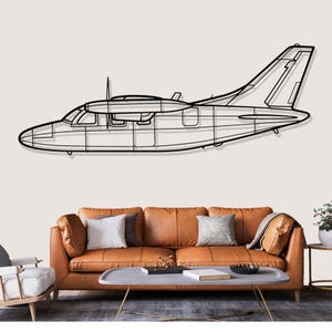 May include: A black metal airplane wall art piece. The artwork depicts the outline of a small aircraft, showcasing the wings, fuselage, and tail. The art is mounted above a brown leather sofa with decorative pillows.