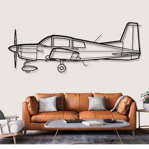 May include: A black metal airplane wall art piece. The artwork depicts a side profile of a small aircraft with a propeller, wings, and tail. The plane is mounted on a light-colored wall above a brown leather sofa.