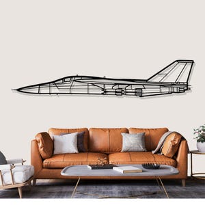 Peut inclure: Une œuvre d'art murale en métal noir représentant le contour d'un avion à réaction. L'œuvre est fixée sur un mur clair au-dessus d'un canapé en cuir marron avec des coussins. Le design du jet comprend des ailes, une queue et un fuselage détaillés.