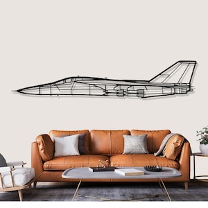 Peut inclure: Une œuvre d'art murale en métal noir représentant le contour d'un avion à réaction. L'œuvre est montée sur un mur de couleur claire au-dessus d'un canapé en cuir marron. La conception du jet comprend des ailes, une queue et des détails du cockpit.
