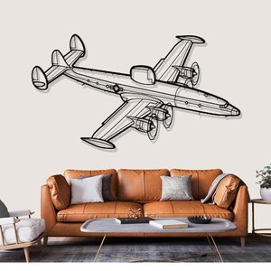 May include: A black and white line drawing of a vintage airplane, mounted on a wall above a brown leather sofa. The aircraft features multiple propellers and wings, creating a retro aviation theme.