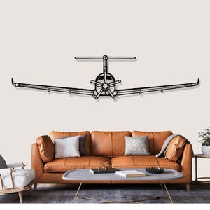 Könnte beinhalten: Eine Wanddekoration aus schwarzem Metall in Form eines Flugzeugs. Das Flugzeug hat einen Propeller und Flügel. Es ist an einer hellen Wand über einem braunen Ledersofa mit Kissen befestigt.