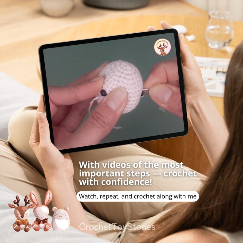 K&ouml;nnte beinhalten: Eine Person h&auml;lt ein Tablet mit einem H&auml;keltutorial. Der Bildschirm zeigt H&auml;nde, die an einem kleinen, wei&szlig;en geh&auml;kelten Objekt arbeiten. Der Text auf dem Bildschirm lautet: "Mit Videos der wichtigsten Schritte - h&auml;keln mit Zuversicht!"