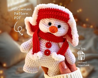 May include: A crocheted snowman doll with a red hat, scarf, and buttons. The snowman has a carrot nose and black eyes. The image includes the text "Snowman Pattern PDF" and "Instant Download".