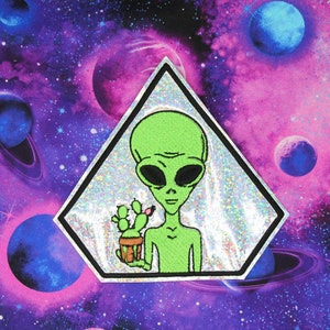 May include: A green alien with large eyes holding a potted cactus in front of a holographic, iridescent, triangle-shaped background with a galaxy pattern.