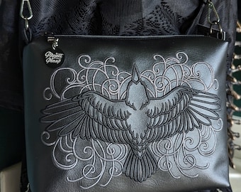 Bolso bandolera mediano negro Filigree Raven con herrajes en tono bronce, monedero bordado y piel vegana.