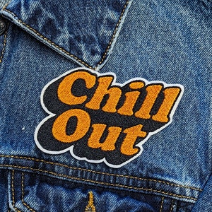 May include: A denim jacket with a black and orange embroidered patch that says "Chill Out" in a retro font.