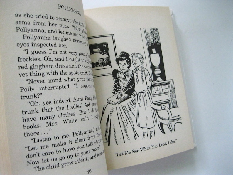 May include: An open book featuring text and a black and white illustration of two women. The illustration depicts a seated woman with a book and a young girl standing nearby. The text on the page reads "POLLYANNA".