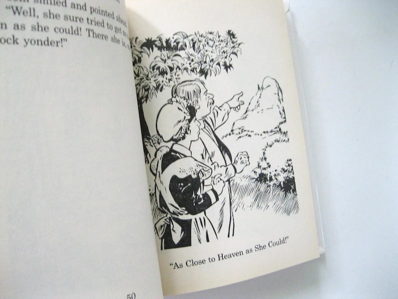 May include: Monochrome illustration from a book. Two figures are pointing towards a mountain. The text "As Close to Heaven as She Could!" is at the bottom of the page.