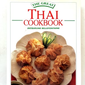 May include: The front cover of a cookbook titled The Great Thai Cookbook by Jacqueline Bellefontaine. The cover features a white background with red and green text and a photograph of seven golden-brown fried wontons on a white plate.