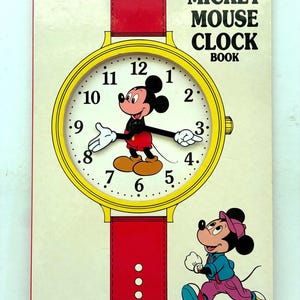 May include: A rectangular Walt Disney's Mickey Mouse Clock Book with a yellow clock face featuring Mickey Mouse as the hands. The cover includes a red watch strap design, a running Mickey Mouse illustration, and the text Tuffy Books and Age 3 and Up.