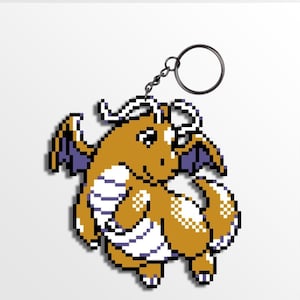 Puede incluir: Un llavero pixelado con un dragón con acentos naranjas, blancos y morados. El dragón tiene alas y una cola rizada, sujeto a un llavero de metal.